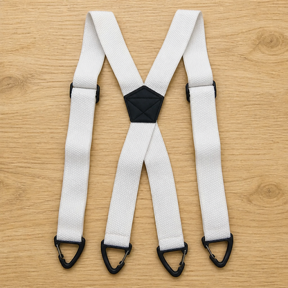 White X-back suspenders laid flat on a wooden surface, with a black centre patch and four black triangular clips. 10