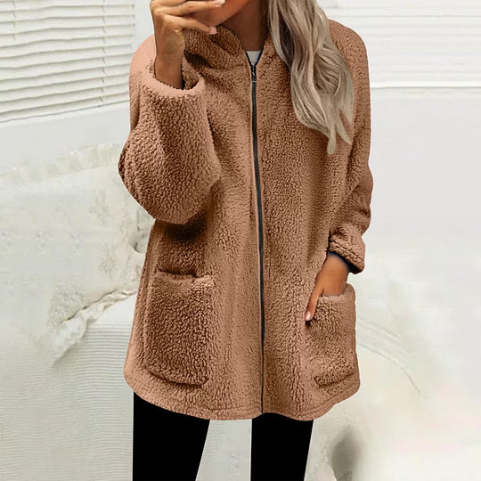 Model wearing the zipped fluffy fleece jacket in light brown, hand in a patch pocket 2