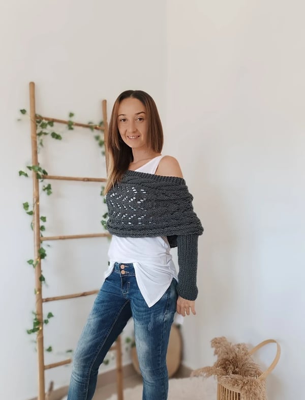 Dark grey wrap worn off one shoulder with one sleeve hanging down, model turned slightly to the side. 4