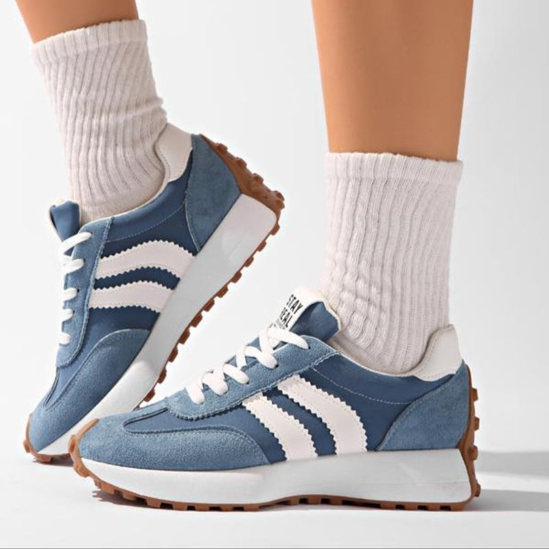 Side view of blue suede trainers with white stripes, worn with chunky white ribbed socks 8