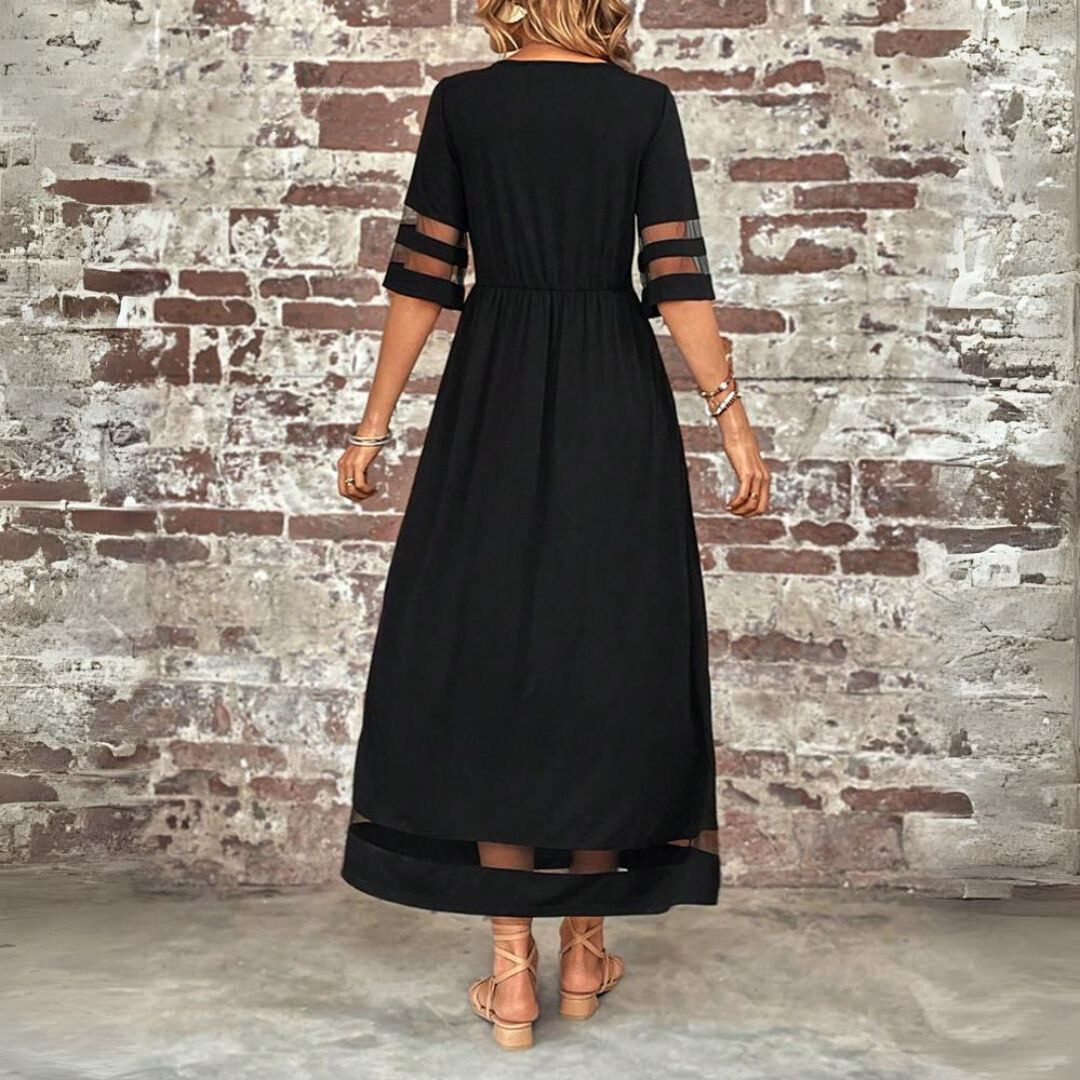 Back view of the black maxi dress, showing the gathered waist, sheer panels on the sleeves and the mesh band at the hem. 3
