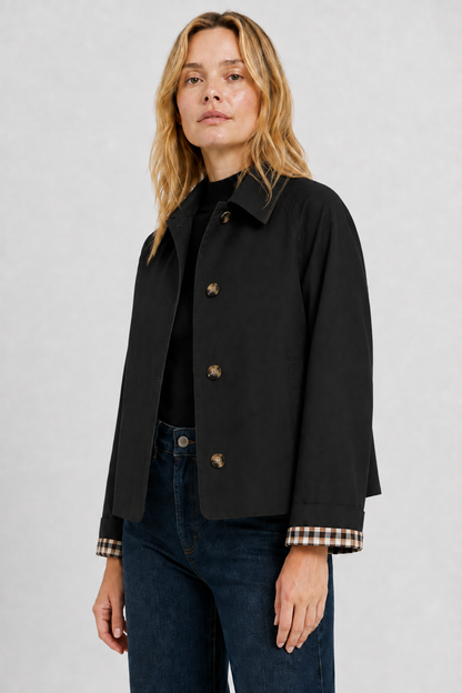 Black jacket in three-quarter view, showing the collar, horn-style buttons and turned-back gingham cuffs. 20
