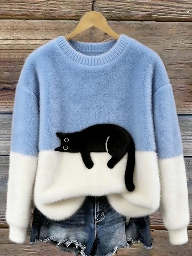 Light blue and white colour-block fluffy jumper on a wooden hanger, showing a black cat lying along the colour join. 2