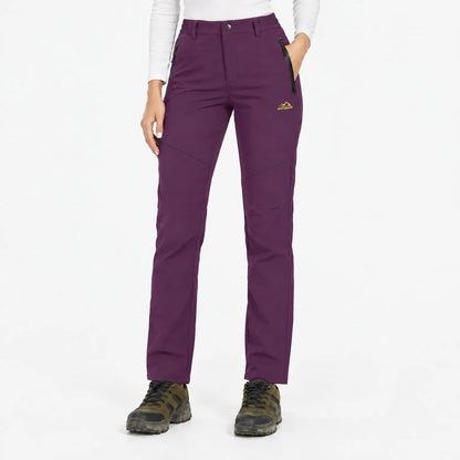 Front view of the trousers in a rich plum purple, with one hand in the pocket 18