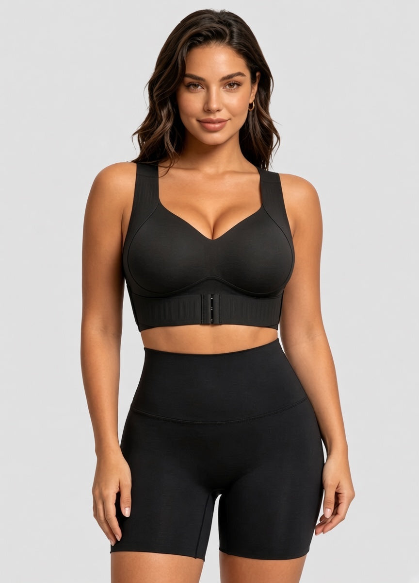Model facing forward in the black bra with matching high-waisted shorts against a grey backdrop 13
