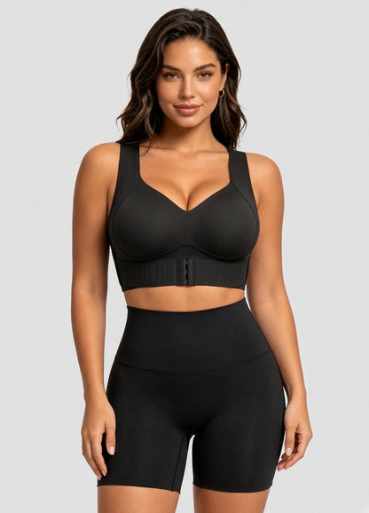 Model facing forward in the black bra with matching high-waisted shorts against a grey backdrop 13