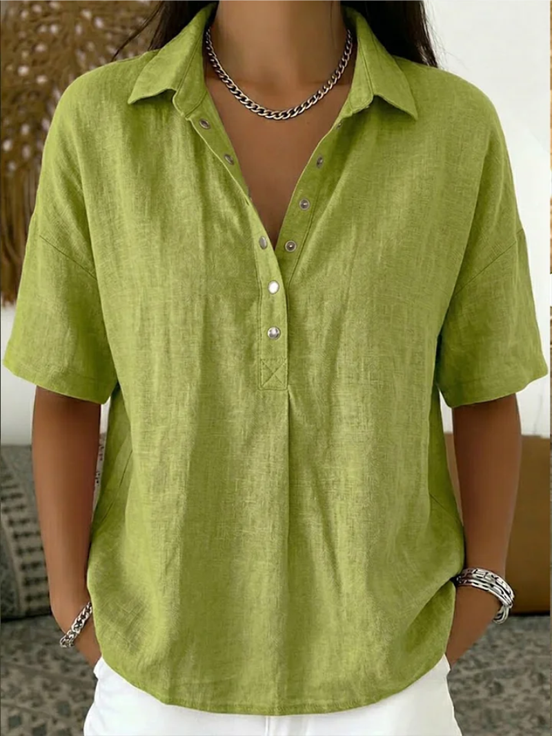 Short-sleeved blouse in lime green, worn by a model with a chain necklace and white trousers 4