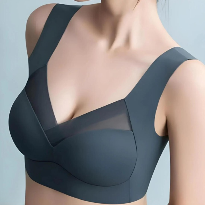 Close-up of a model wearing the slate-blue bra from the front, showing the V-neck mesh panel and wide straps. 2