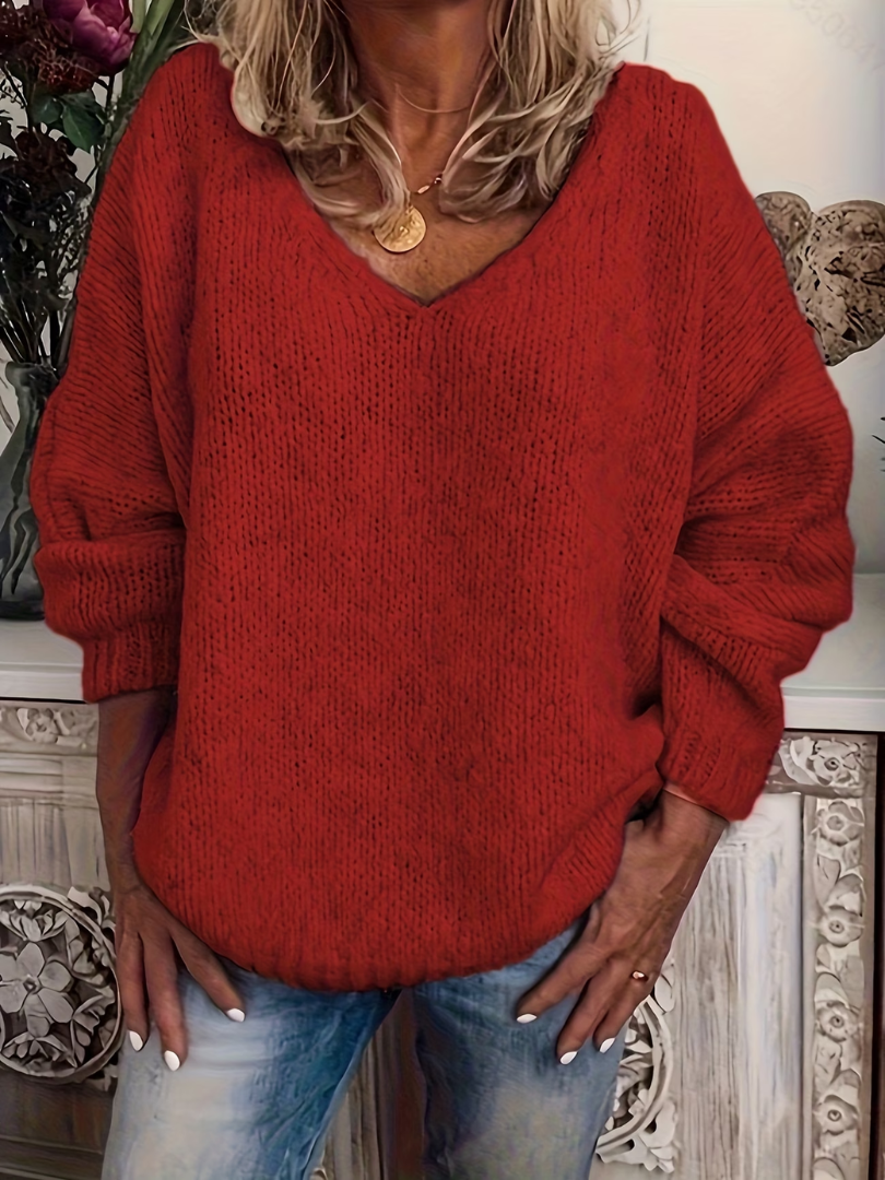 Woman wearing the chunky knit V-neck jumper in bright red, front view, showing the loose relaxed silhouette. 5
