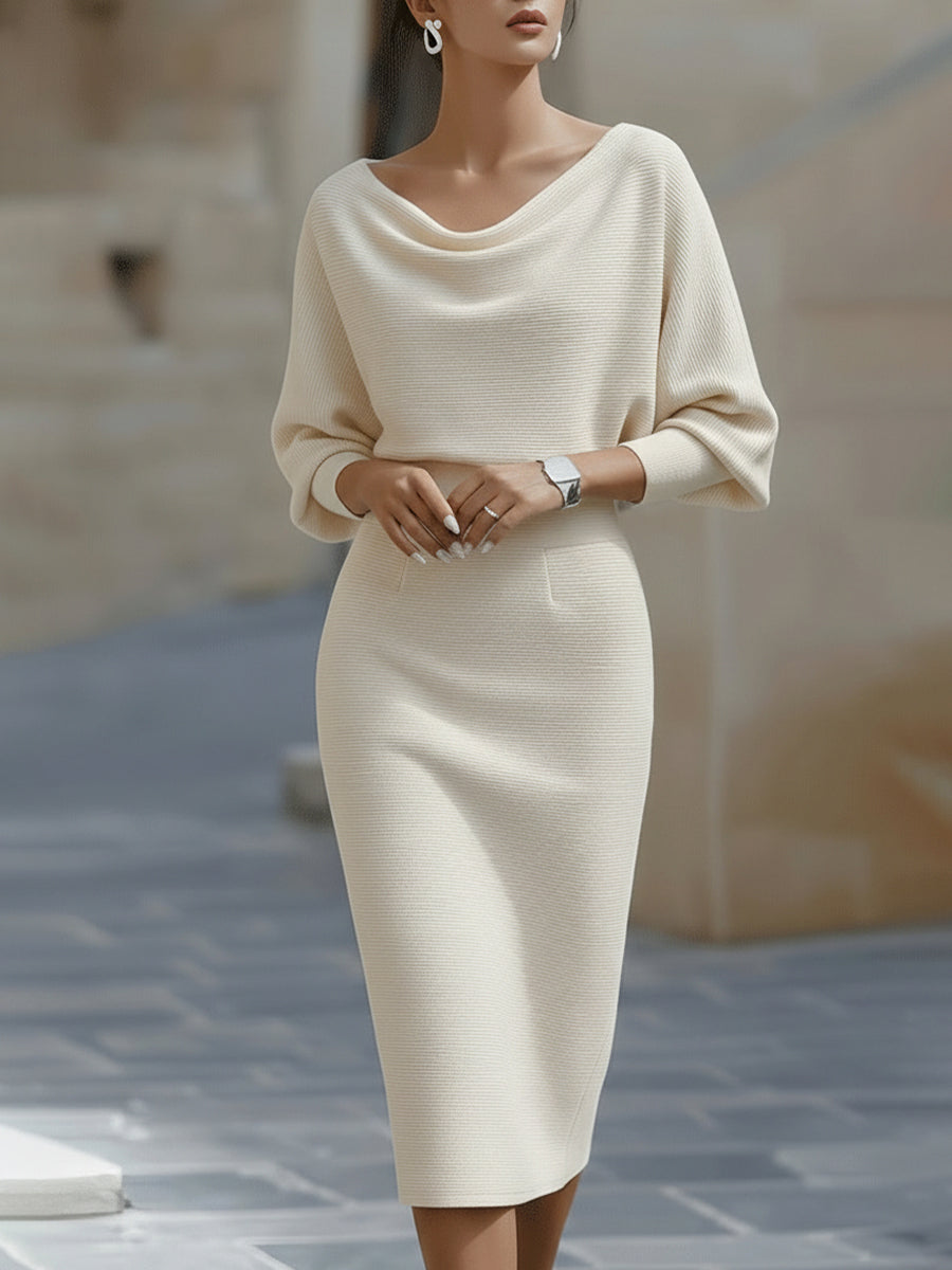 Model wearing the cream version of the dress, hands clasped at the waist, front view 3