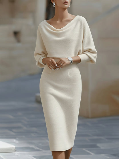 Model wearing the cream version of the dress, hands clasped at the waist, front view 3