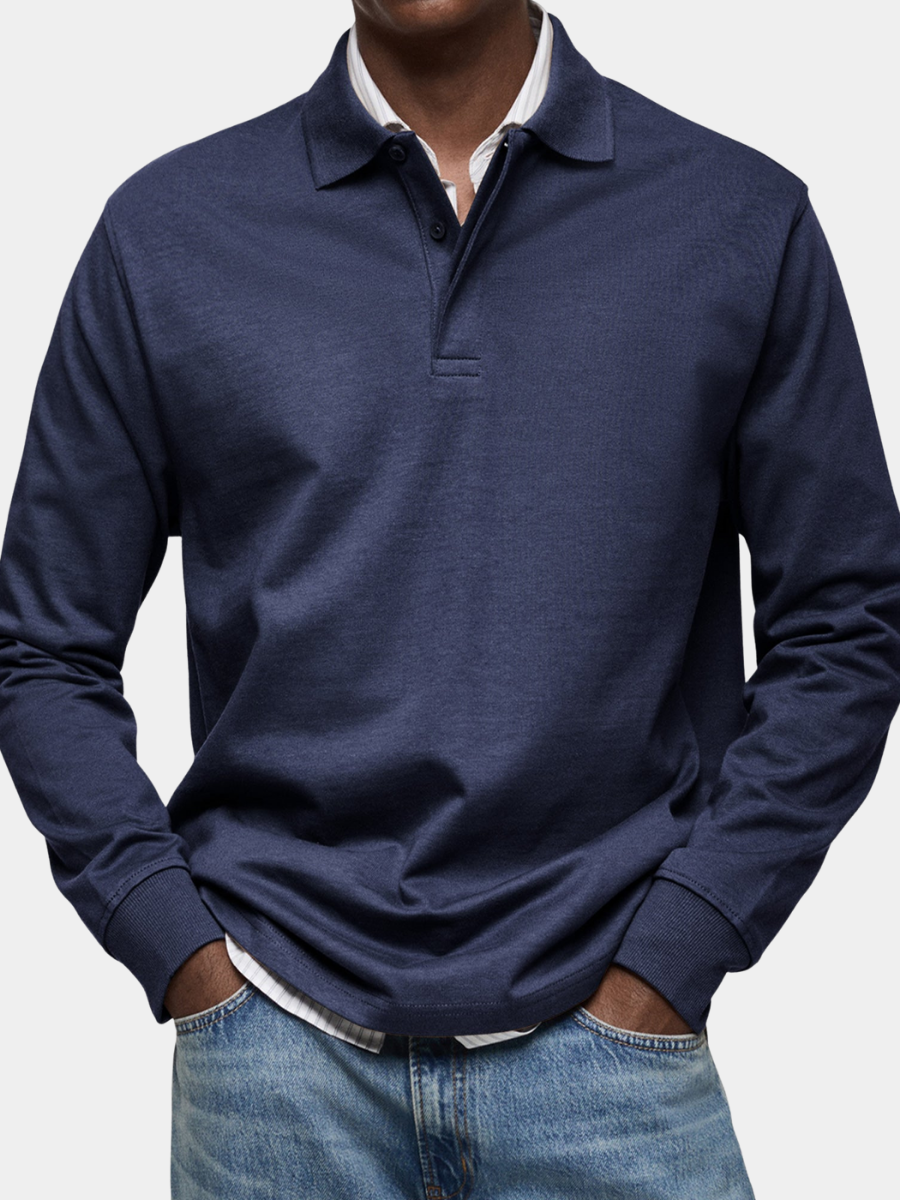 Navy long sleeve polo with ribbed cuffs, worn by a model over a striped shirt with jeans 1