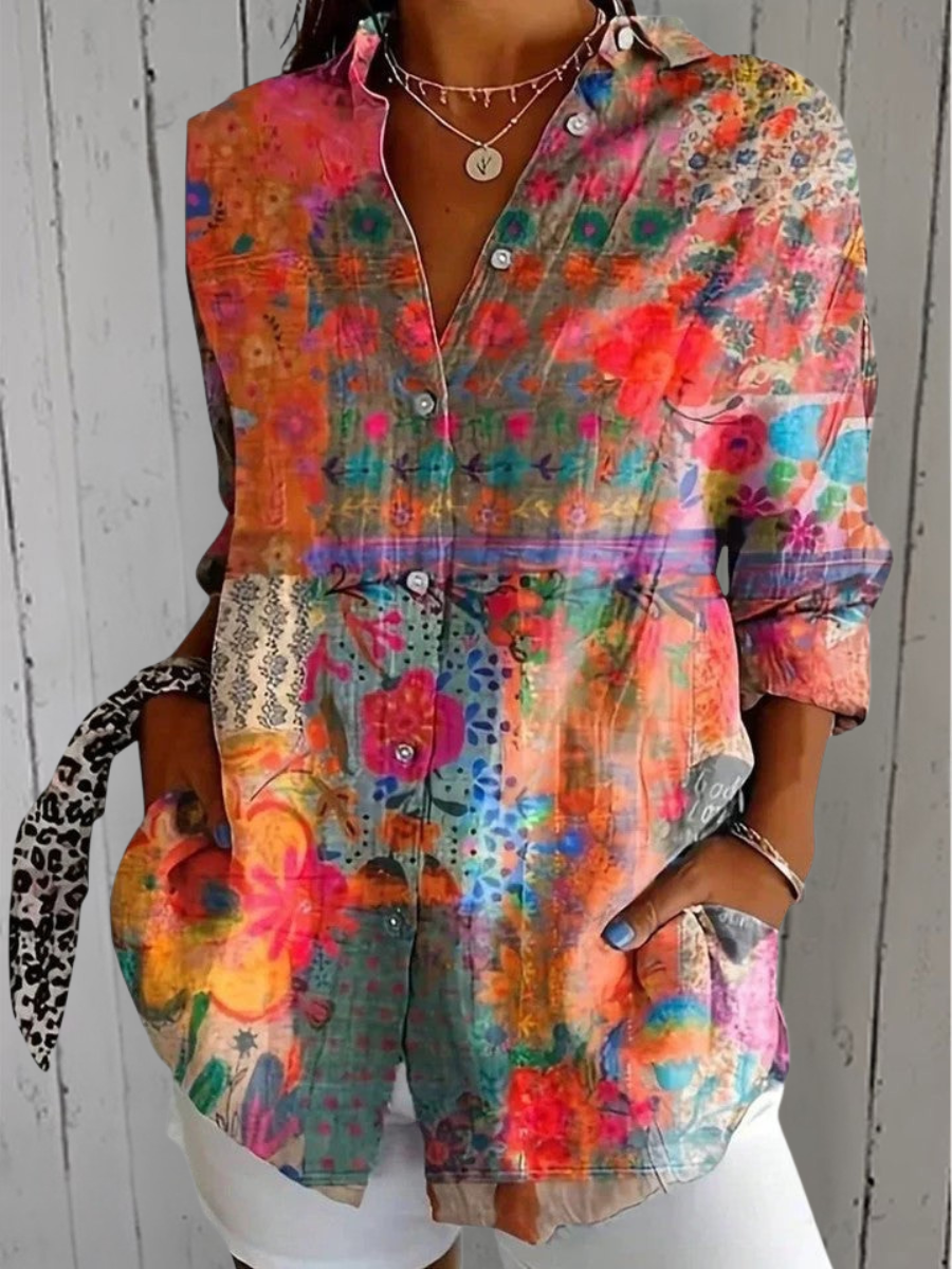 Model wearing the shirt in a patchwork floral print of orange, pink and teal panels, worn open at the collar. 2