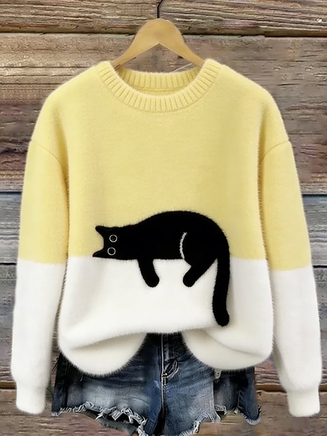 Pale yellow and white fluffy jumper with black cat motif, hanging on a wooden background 8