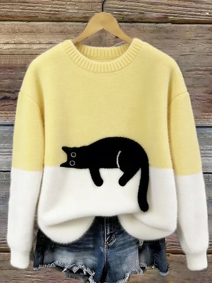 Pale yellow and white fluffy jumper with black cat motif, hanging on a wooden background 8