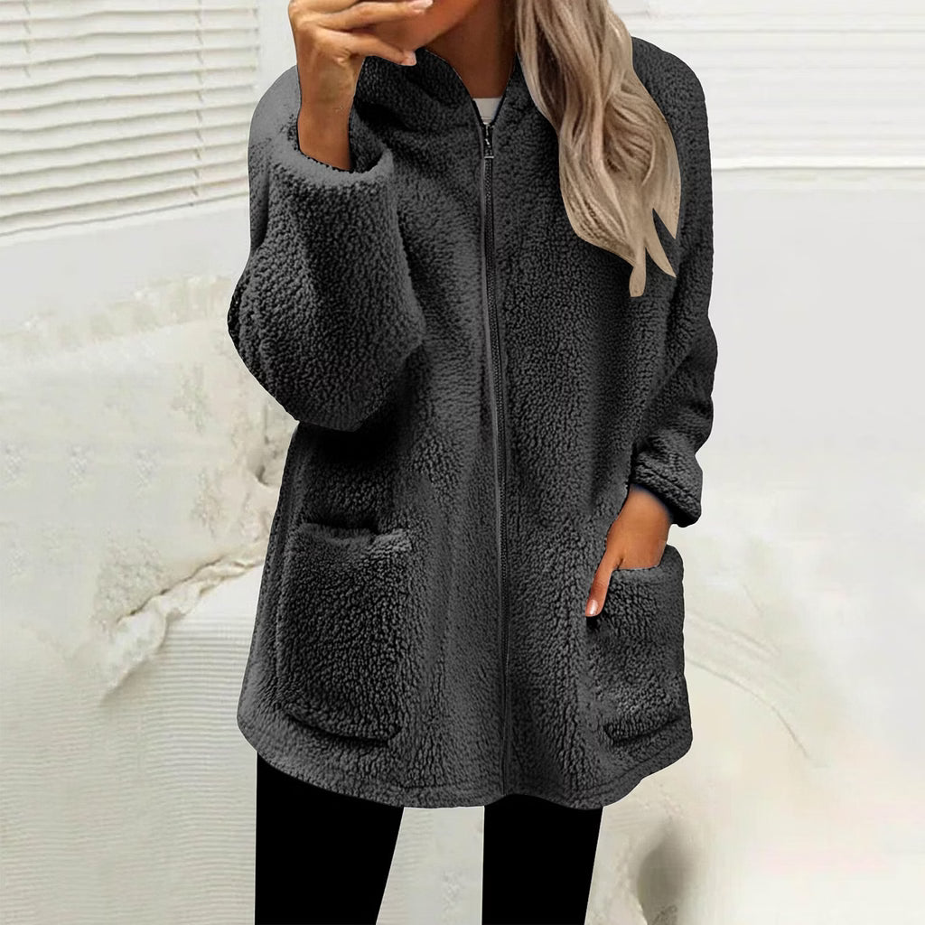 Model wearing the zipped fluffy fleece jacket in dark charcoal grey with black leggings, one hand in a pocket 1