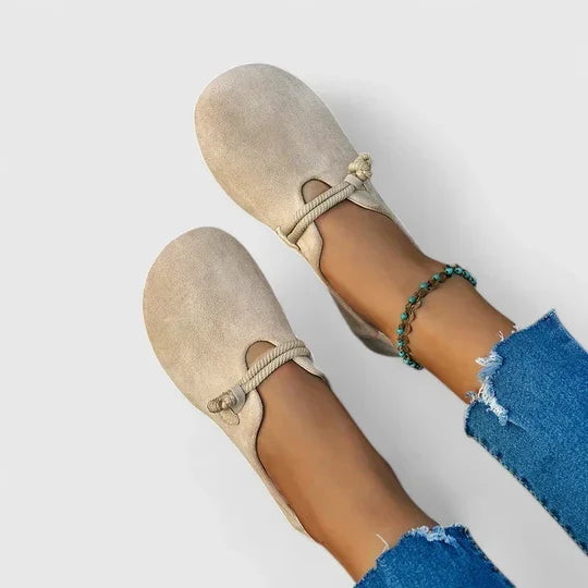 Beige suede loafers with twisted rope straps, seen from above on a model wearing ripped jeans 1