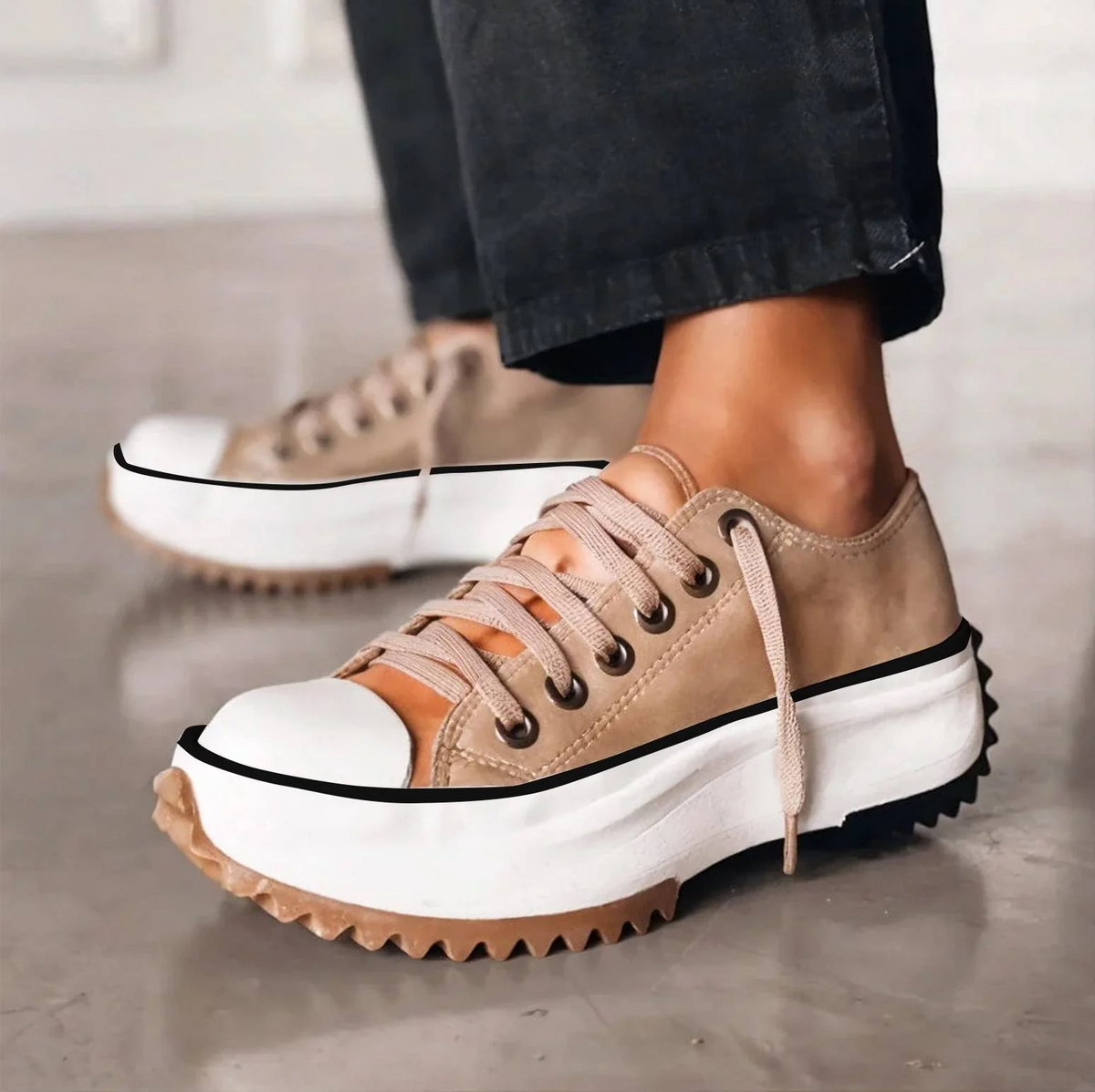 Side view of beige lace-up platform trainers worn with black trousers, showing the chunky white sole and zigzag gum tread. 1