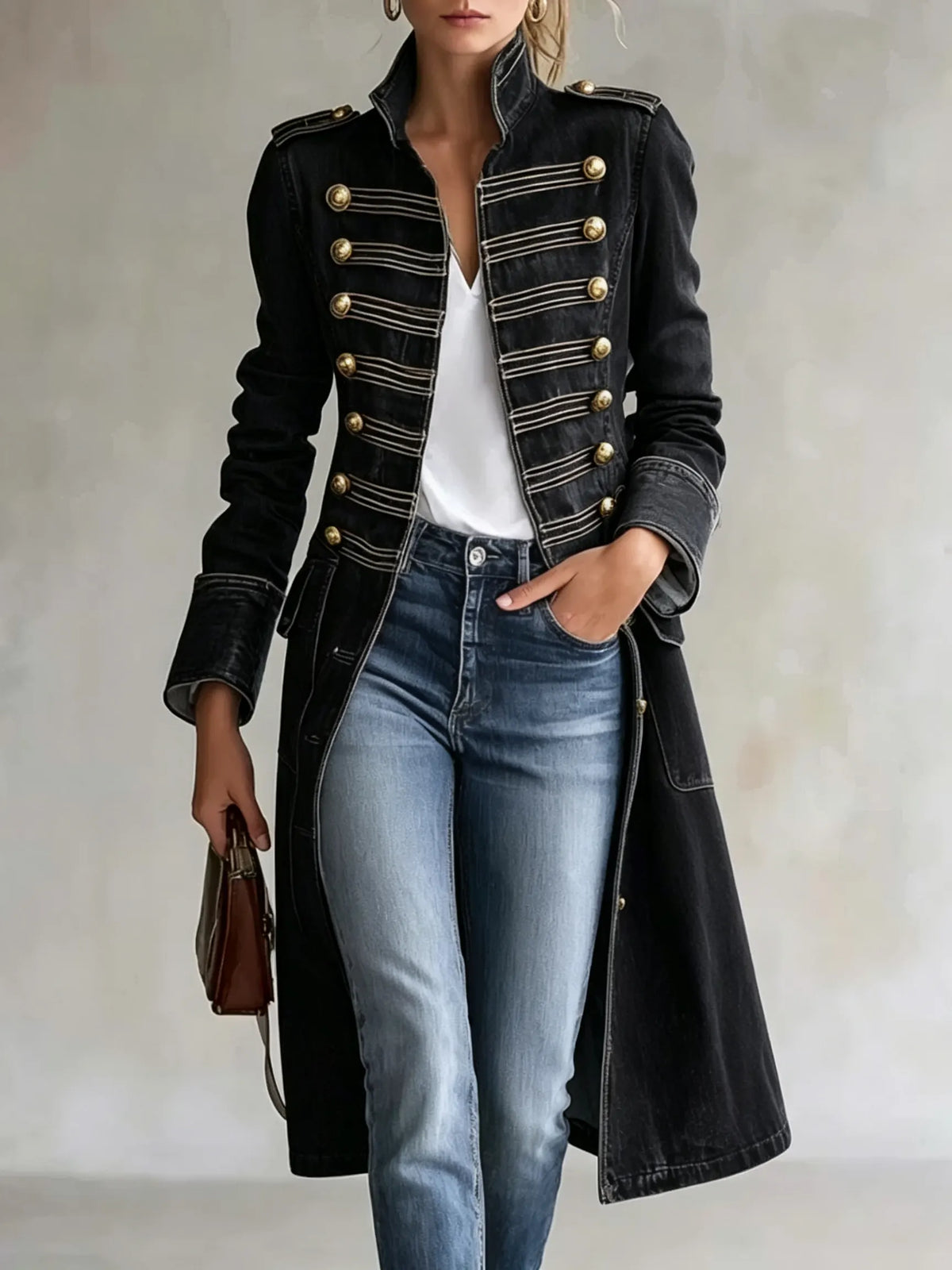 Model wearing the coat in a black version with gold buttons and light braiding, styled with a white top and jeans. 9