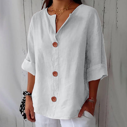 Model wearing the loose blouse in white, showing the relaxed fit, three brown buttons, notched V-neck and cuffed sleeves. 9