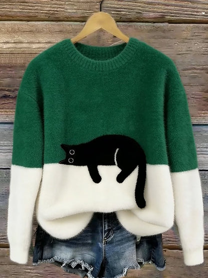 Green and white fluffy jumper with black cat motif, hanging on a wooden background 5