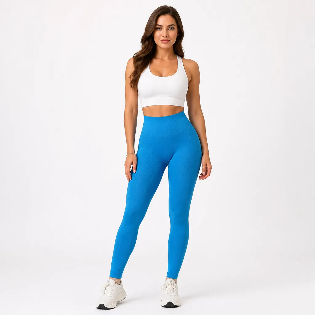 Full-length front view of plain bright blue high-waisted leggings with a white racerback sports bra and white trainers. 12