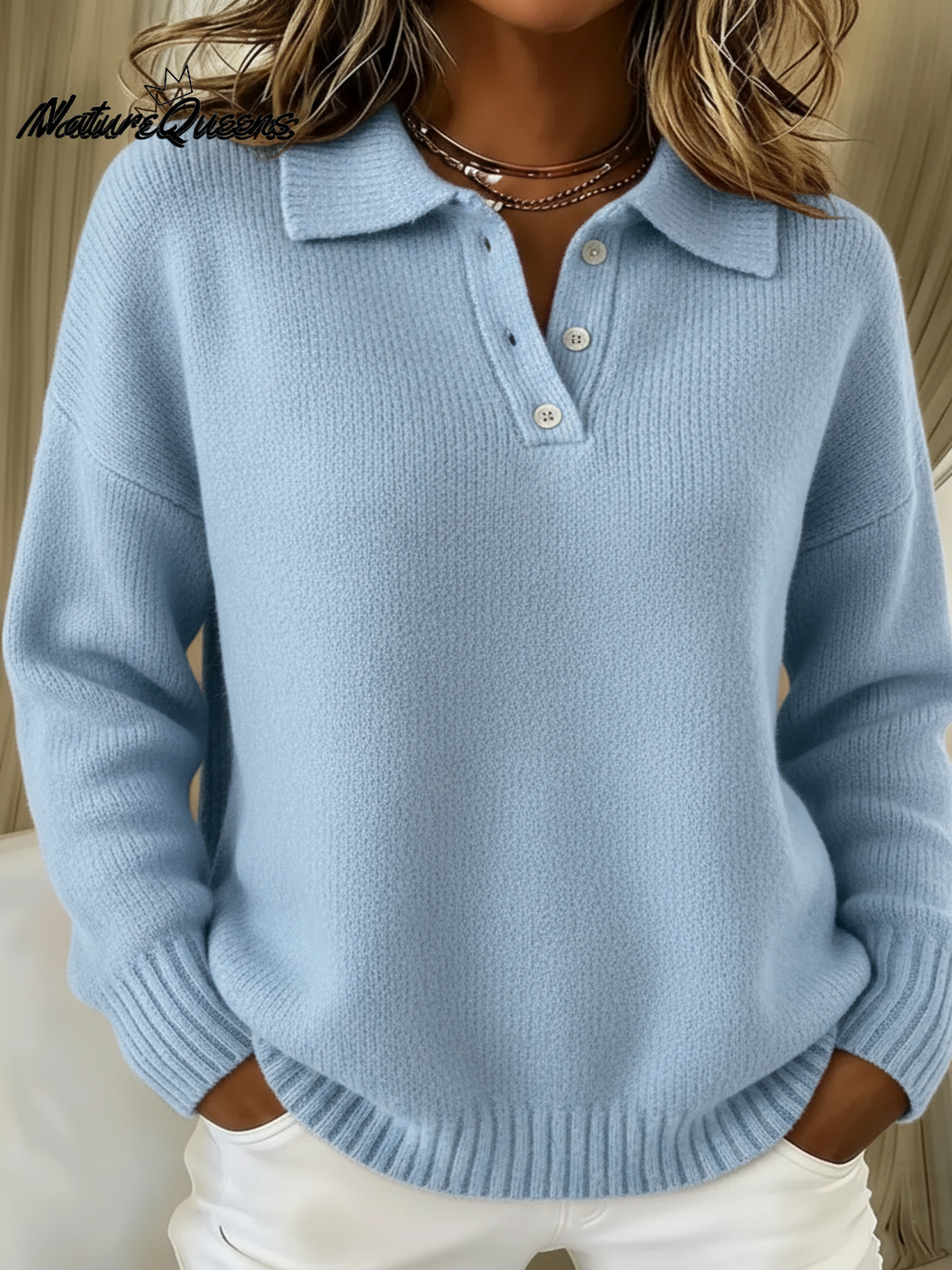 Model wearing the knitted polo sweater in light blue, with a folded collar, three-button placket and ribbed cuffs and hem. 1