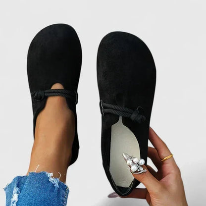Black loafers from above, one worn and one held in hand to show the pale insole 4