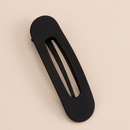 Matte black slim flat clip with an oval opening, shown from above on a cream background 5