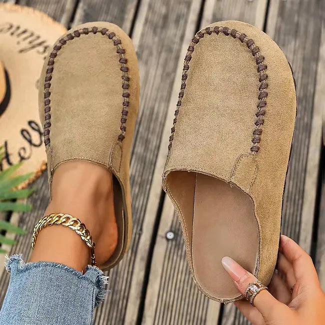 Light khaki version seen from above, one clog worn with a gold ankle chain and the other held to reveal the pale insole. 2