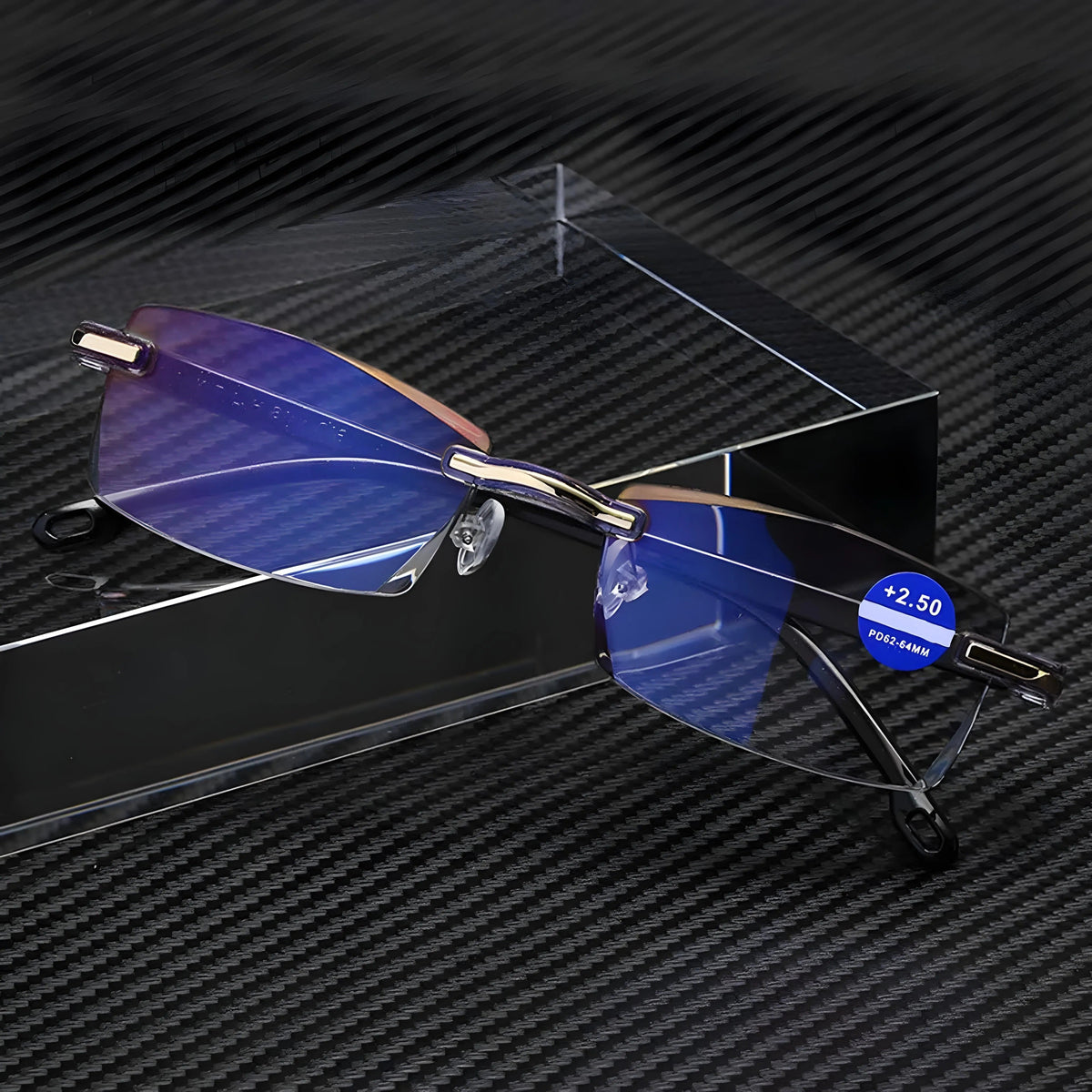 Rimless glasses with gold-coloured hinge details on a black carbon-fibre surface beside a clear block, with a strength sticker on one lens. 5