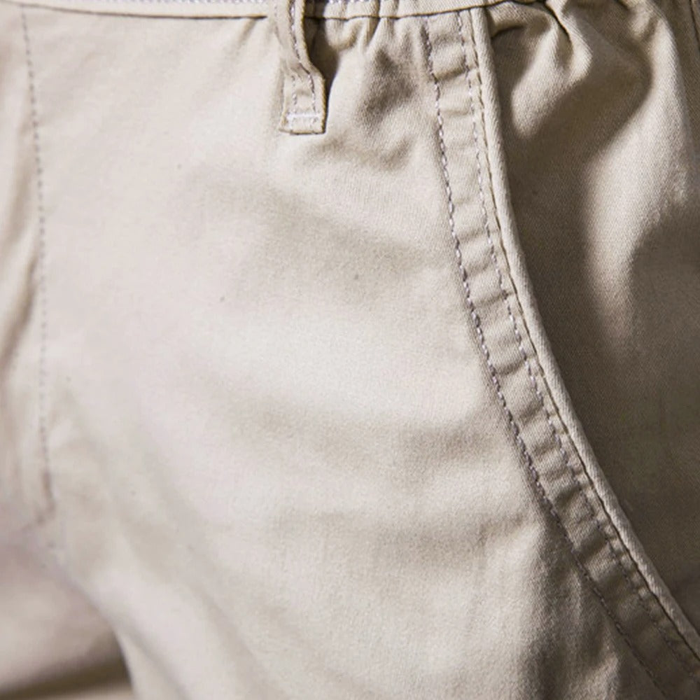 Close-up of beige fabric showing the side pocket opening with contrast stitching and a belt loop 3