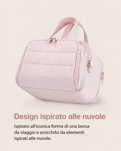 Pink quilted bag from the side, showing its rounded travel-bag shape with horizontal quilting, zip pulls and padded handles. 6
