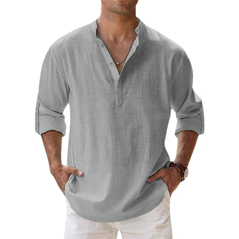 Model wearing the light grey Henley shirt with a button neck, rolled sleeves and white trousers. 6