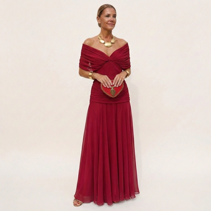 Full-length view of a plain deep red version with a twisted off-the-shoulder neckline, ruched waist and flowing chiffon skirt. 5