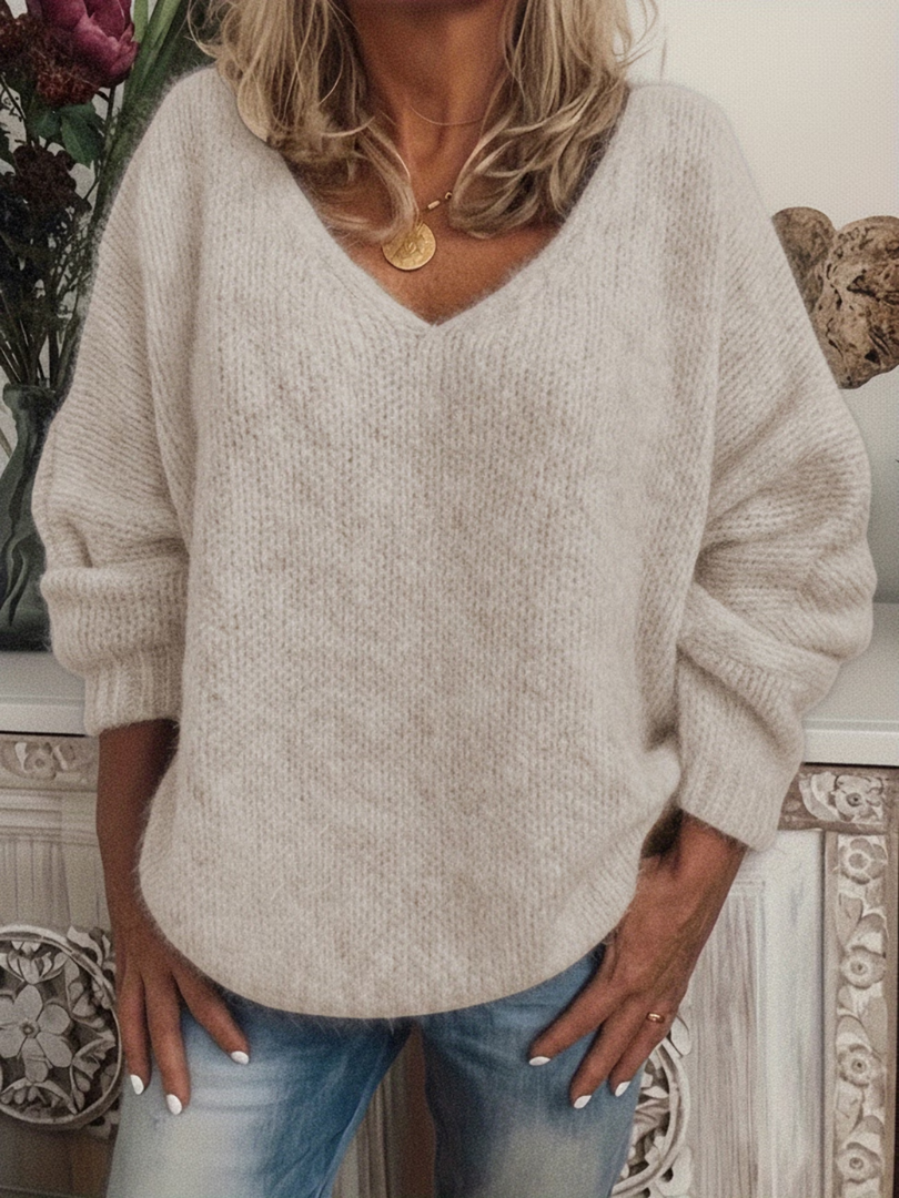Woman wearing the soft, slightly fluffy knit V-neck jumper in cream, front view, hands resting in jeans pockets. 4