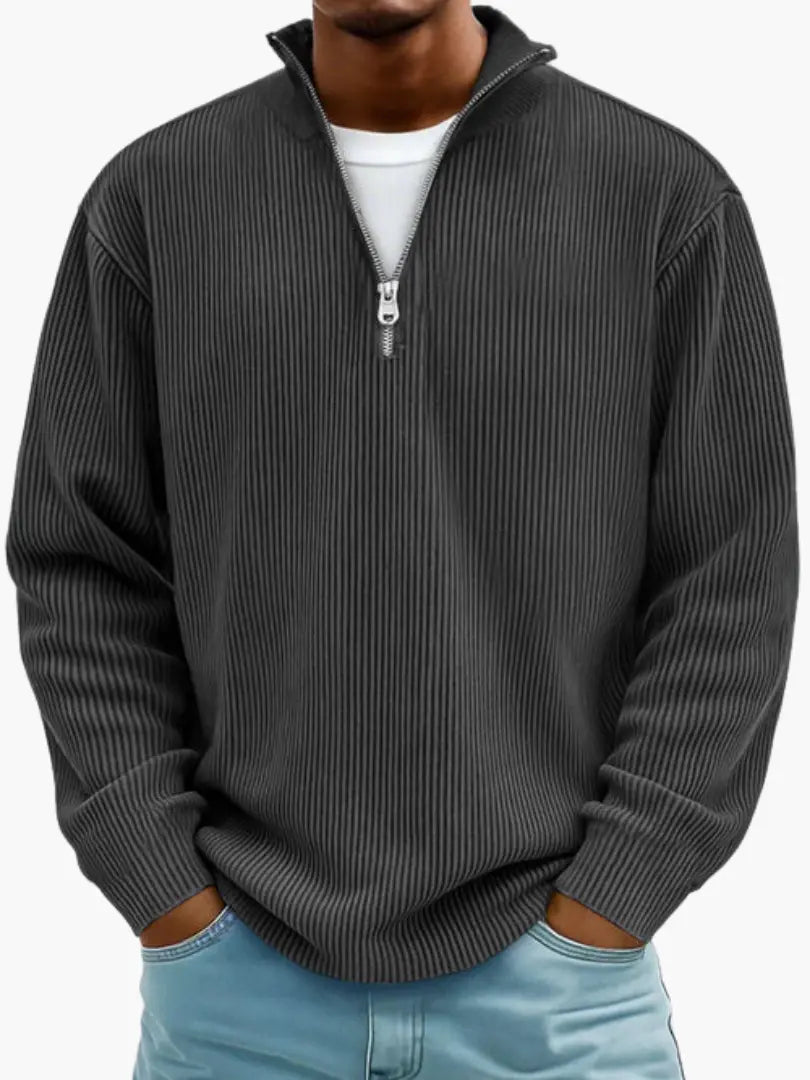 Man wearing the ribbed quarter-zip jumper in charcoal black over a white tee, hands in the pockets of light blue jeans. 7