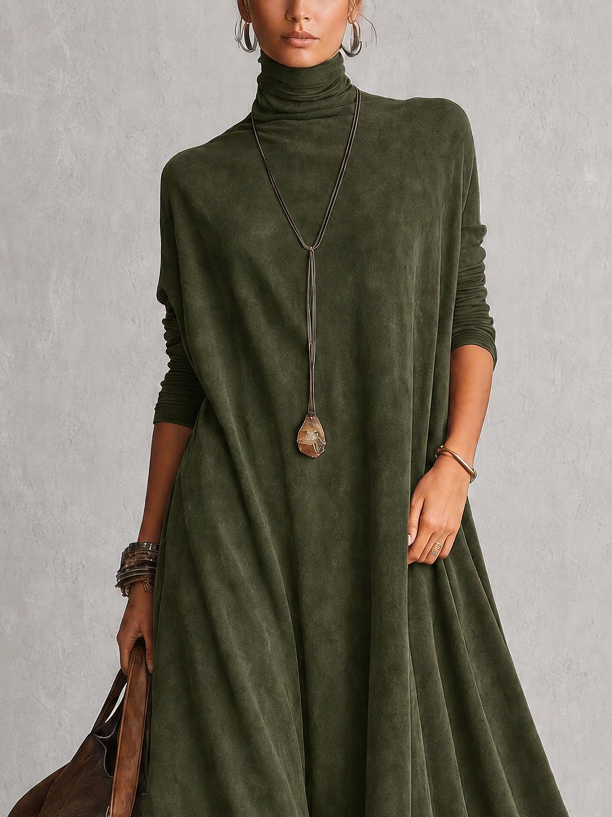 Close-up of the olive green dress's turtleneck and draped bodice with long pendant necklace 15