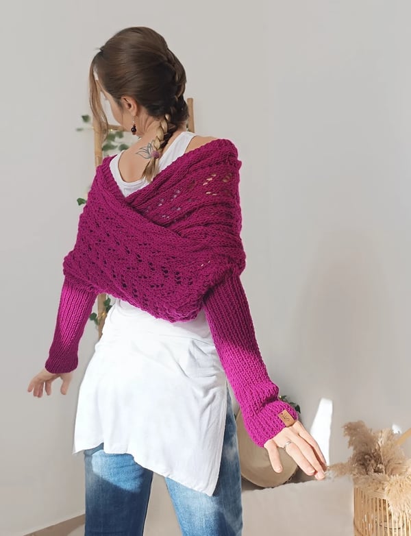 Back view of a magenta-pink wrap crossed over the shoulders, with ribbed sleeves and a model's plait. 11