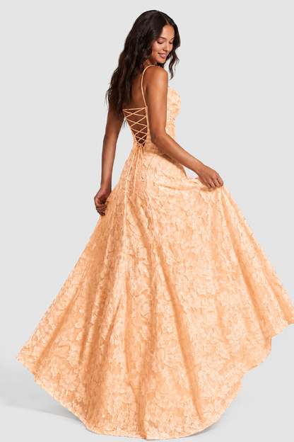 Back view of the peach floral lace gown as the model lifts the skirt, showing the lace-up back and fullness. 15