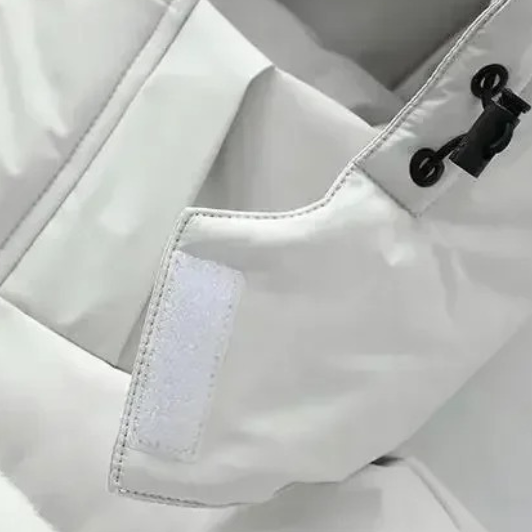 Close-up of the white coat's hood drawcord toggle and a hook-and-loop fastening tab 5
