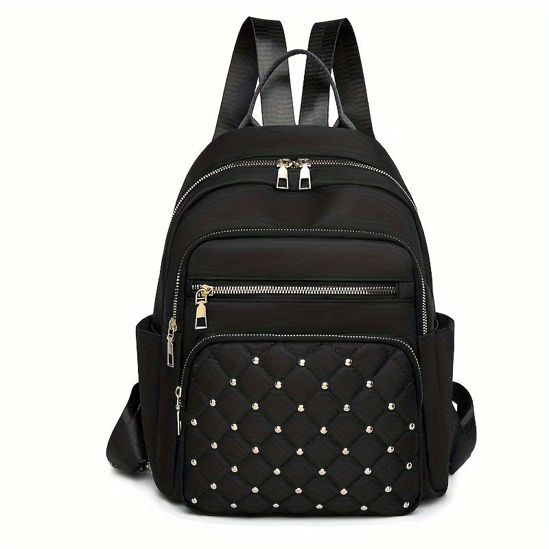 Black nylon backpack seen from the front, with a quilted, gold-studded front pocket and gold zips 1