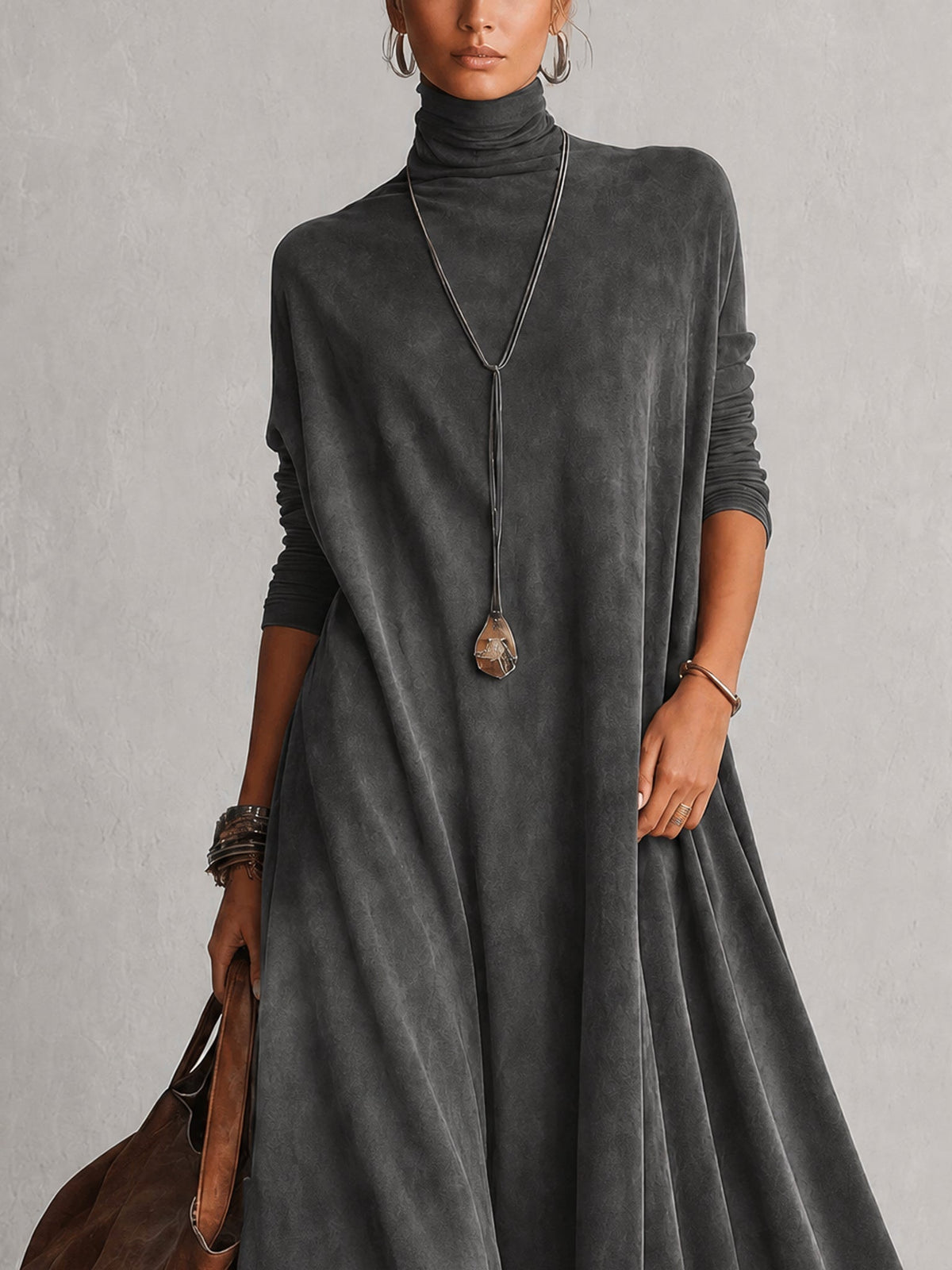 Close-up of the charcoal grey dress's high neck, sleeves and soft draped fabric 17