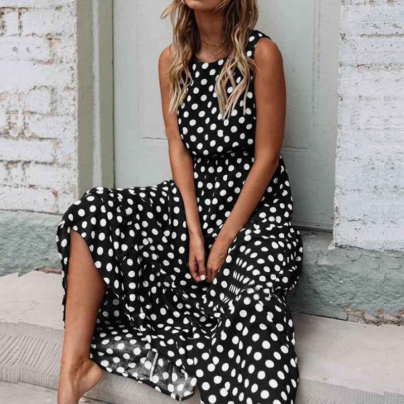 Woman seated on stone steps wearing the black polka dot dress with white spots and gathered waist 4