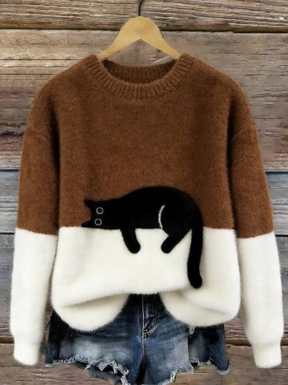 Brown and white colour-block fluffy jumper on a hanger, with a black cat lying along the colour join. 10