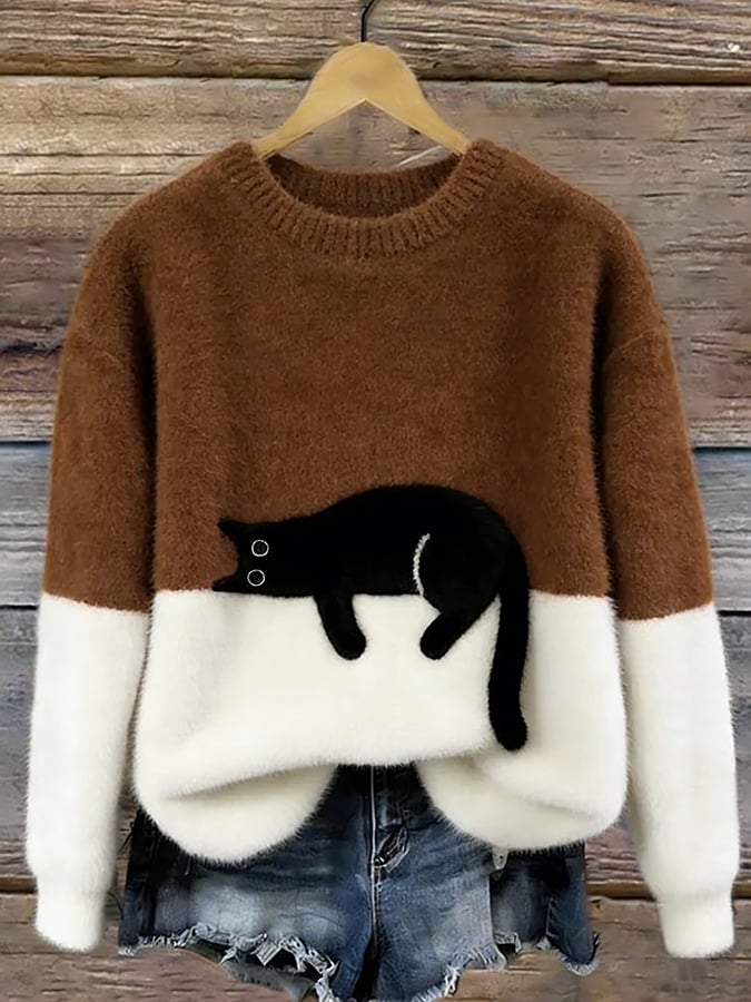 Brown and white fluffy jumper with black cat motif, hanging on a wooden background 10