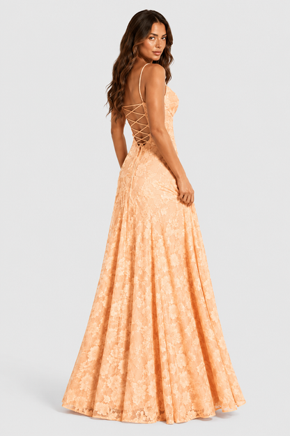 Peach lace gown from behind, model looking back over her shoulder to show the criss-cross lace-up back and flared skirt. 14