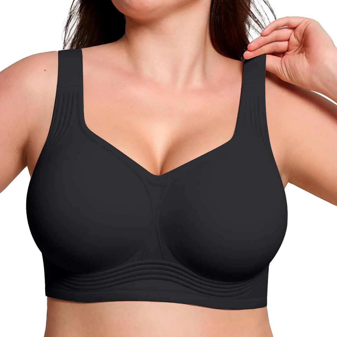 Close-up front view of the black wireless bra worn by a model, hand lifting a strap 5