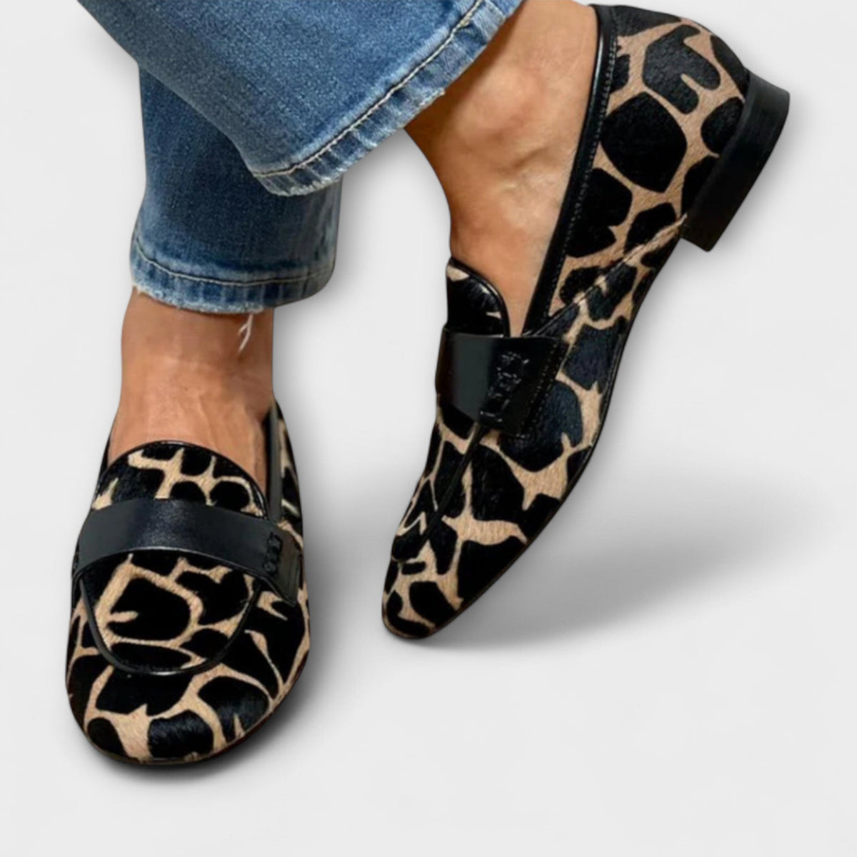 Both loafers worn with cropped jeans, seen from the front and side, showing the black heel and trim around the opening. 3