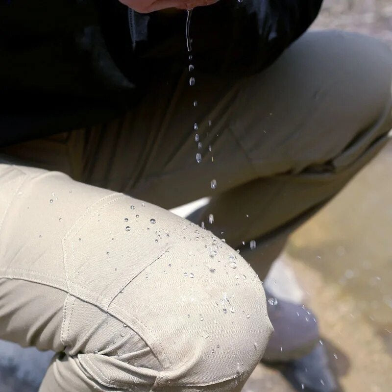Close-up of a khaki trouser knee panel with water droplets beading on the fabric as water pours from above. 7